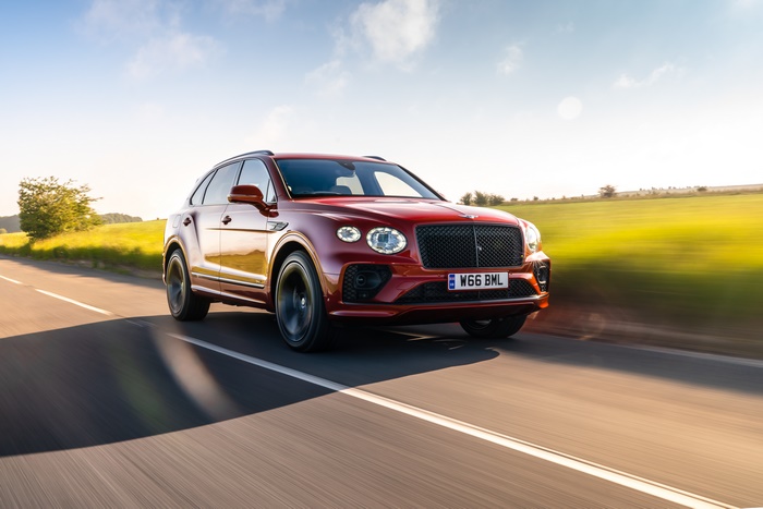 Red Bentley Bentayga Hybrid First Edition SUV on road