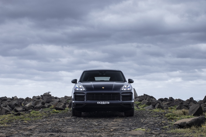 Black Porsche Cayenne GTS SUV on rocky ground