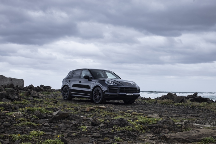 Black Porsche Cayenne GTS SUV on rocky coast