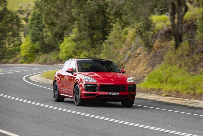 Red Porsche Cayenne GTS Coupé on a winding road