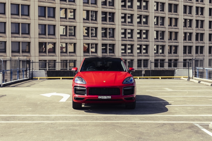 Red Porsche Cayenne GTS Coupé on rooftop parking