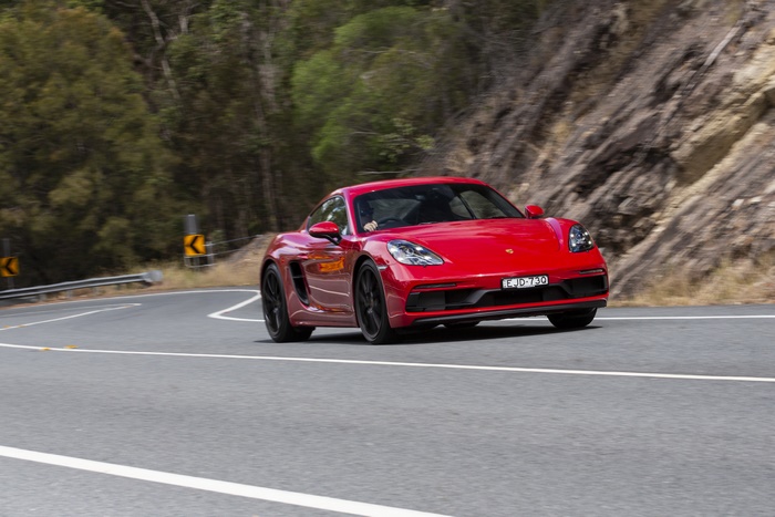 Red Porsche 718 Cayman GTS on a winding road