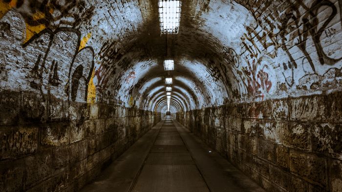 Graffiti-covered tunnel with lights