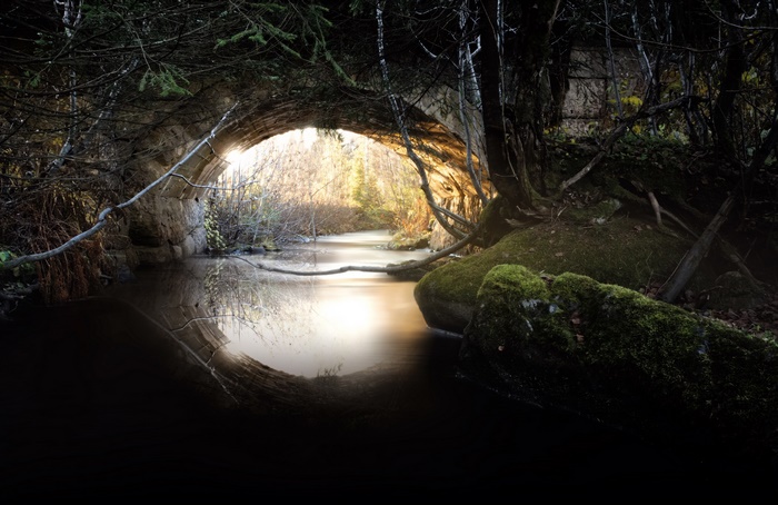 Mystical river under a stone bridge