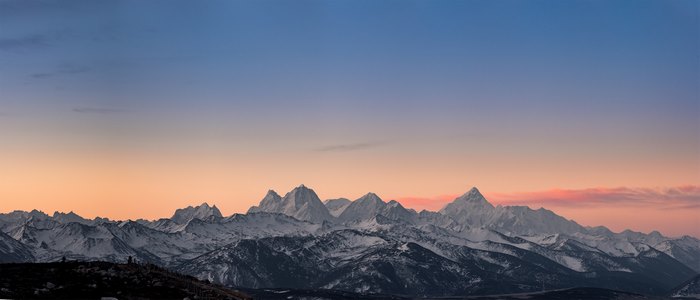 Panoramic snow-capped mountains at sunrise
