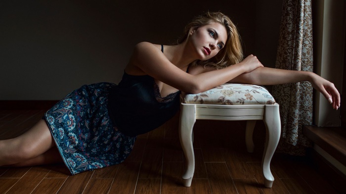 Pensive Woman Leaning on Ornate Stool