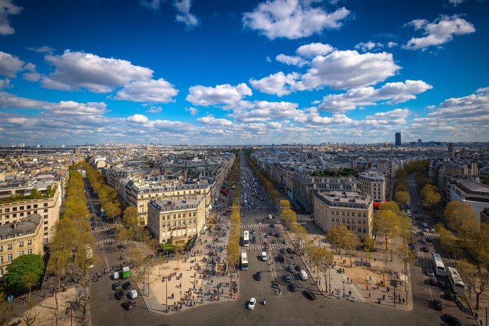 Panoramic Paris cityscape with a grand avenue under blue sky