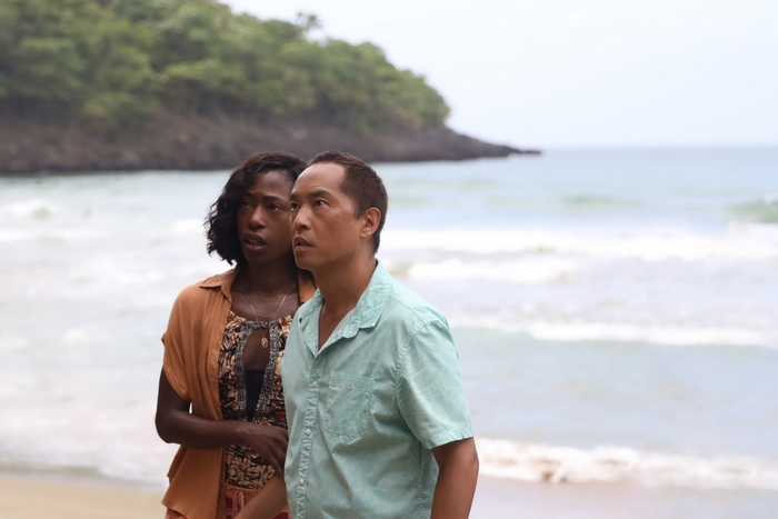 Nikki Amuka-Bird and Ken Leung looking up on a beach