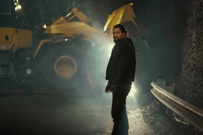 Jason Momoa in Sweet Girl, backlit by heavy machinery