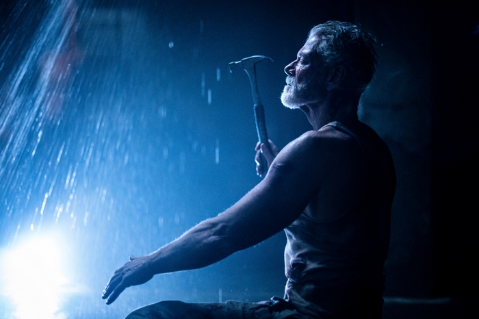 Stephen Lang in intense blue light with hammer