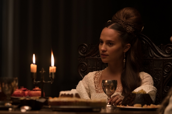 Alicia Vikander as Lady at a candlelit dinner in The Green Knight