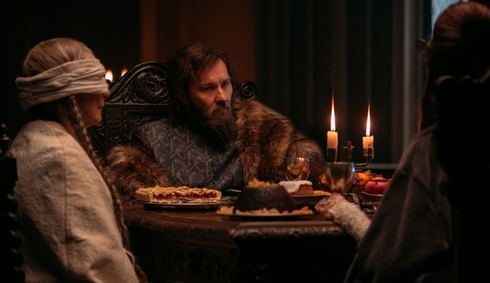 Joel Edgerton's Lord at a somber feast in The Green Knight