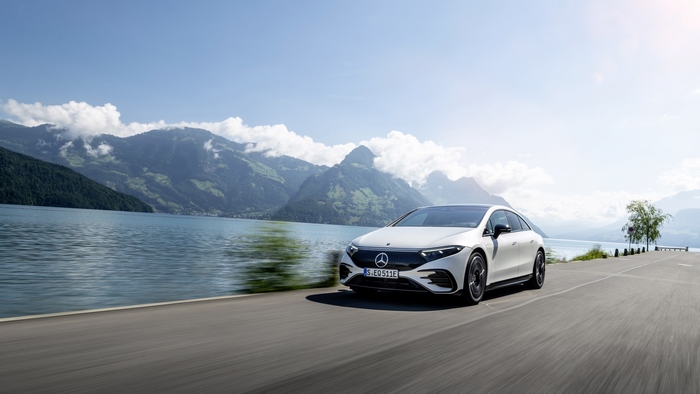 White Mercedes-Benz EQS luxury electric car by a lake
