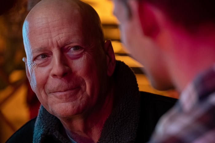 Smiling Bruce Willis with black eye in Cosmic Sin