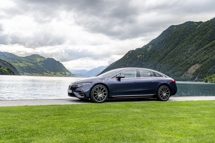 Blue Mercedes-Benz EQS 580 4MATIC electric luxury car by lake.