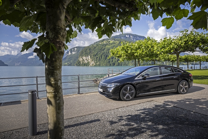 Luxury black Mercedes-Benz EQS electric car by a lake