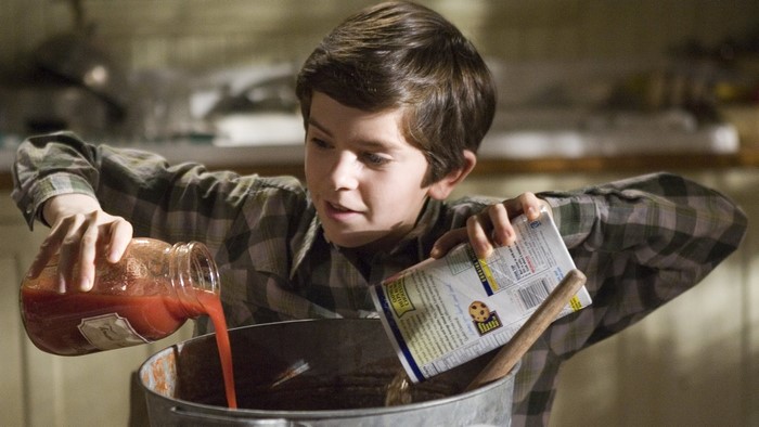 Boy mixing ingredients, an explosive combination in the kitchen