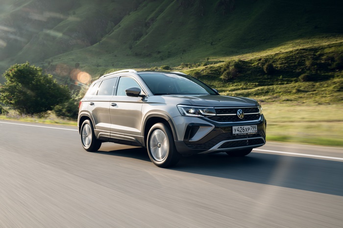 Grey 2021 Volkswagen Taos SUV driving on a mountain road