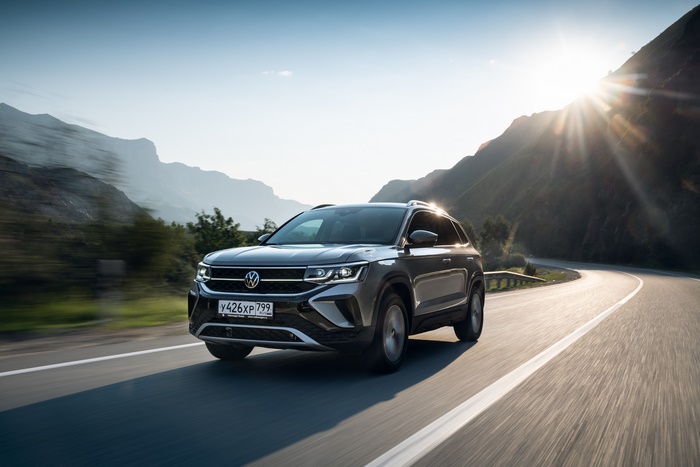 Grey Volkswagen Taos SUV driving on a winding mountain road