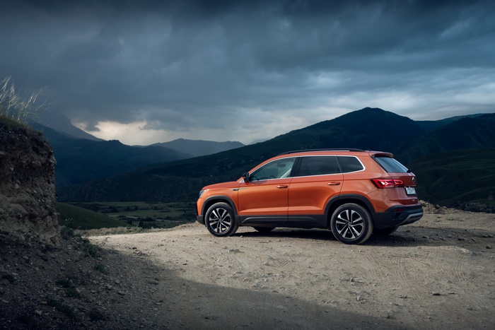 Orange Volkswagen Taos 4MOTION SUV in dramatic mountains