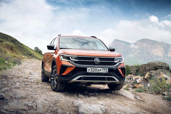 2021 Orange Volkswagen Taos SUV on a rocky mountain road