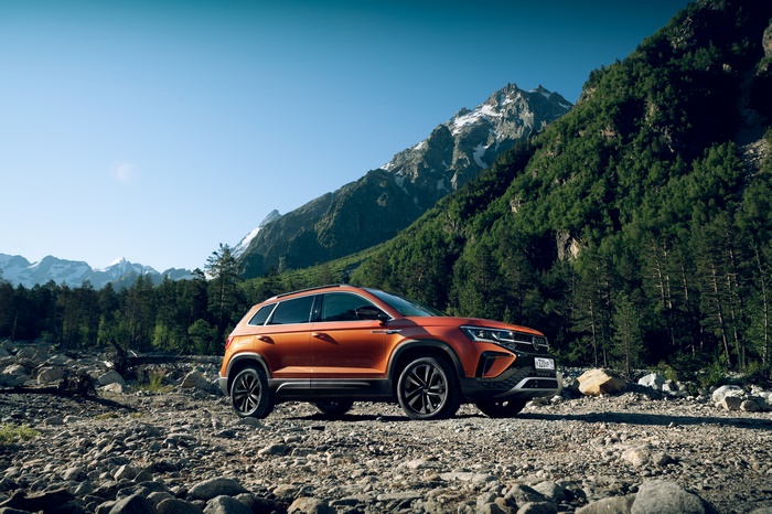 Orange Volkswagen Taos SUV in rocky mountains