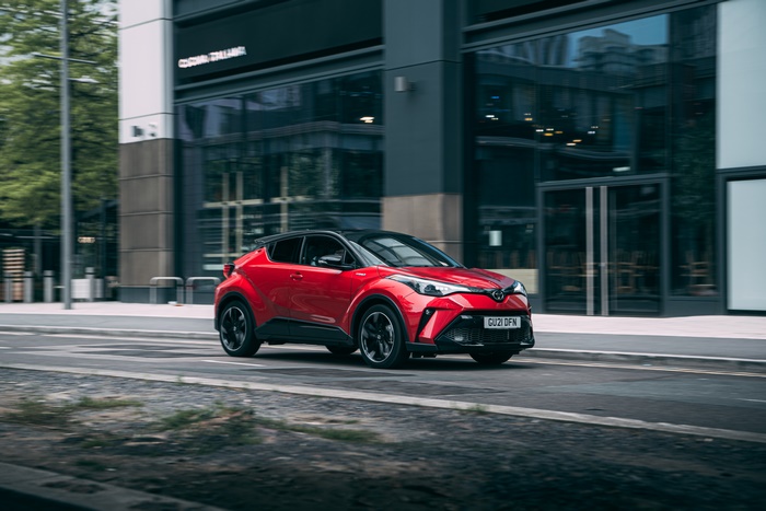 Red Toyota C-HR Hybrid GR Sport SUV driving on street