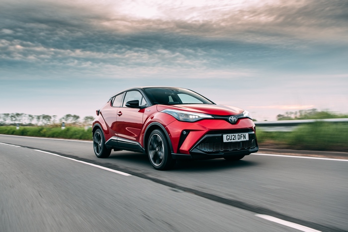 Red Toyota C-HR Hybrid GR Sport SUV driving on road