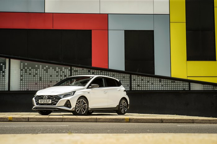 White Hyundai i20 N Line parked against a colorful wall