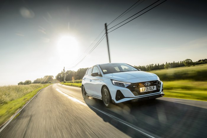 White Hyundai i20 N Line driving on a sunny road
