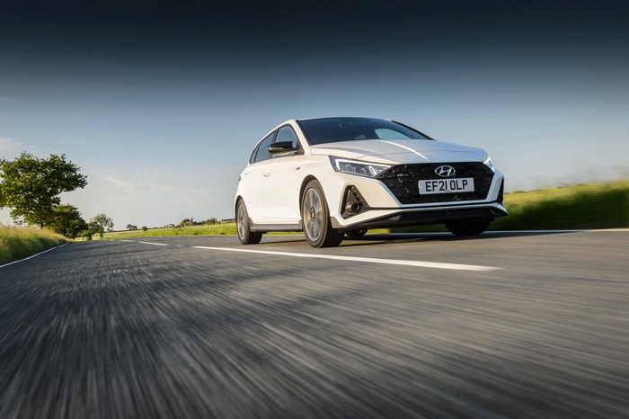 White Hyundai i20 N Line driving on a scenic road