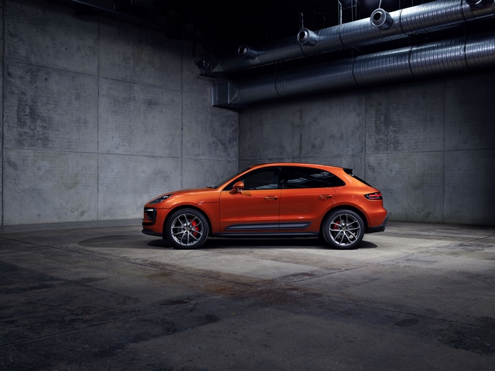 Orange Porsche Macan GTS SUV in a concrete garage
