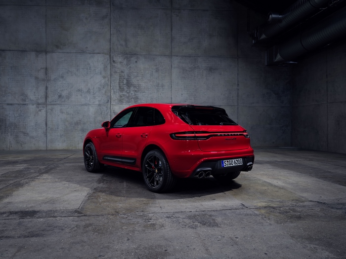 Red Porsche Macan GTS SUV in a dark concrete room