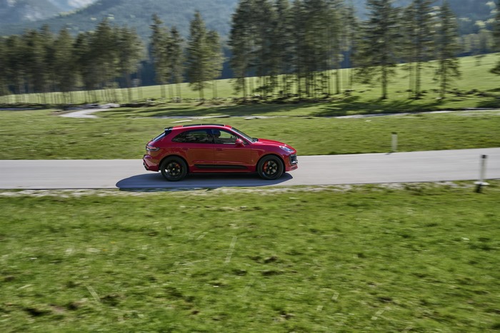 Red Porsche Macan GTS SUV driving on a scenic road