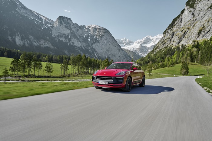 Red Porsche Macan GTS SUV on a scenic mountain road