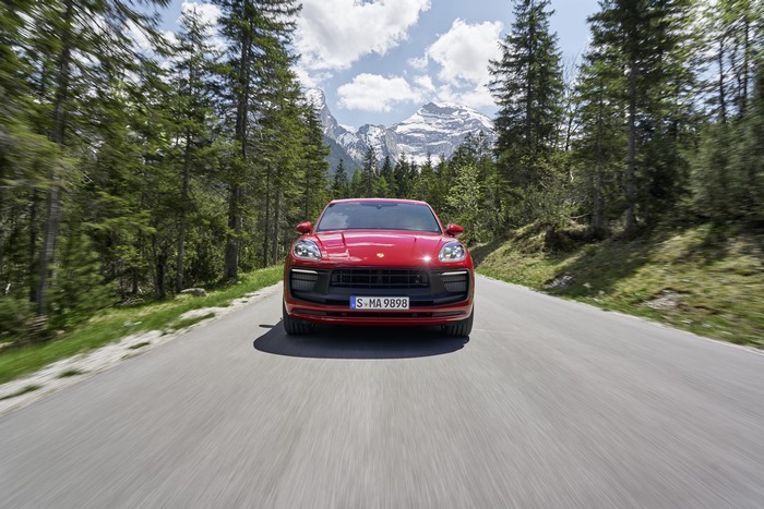 Red Porsche Macan GTS driving on a scenic mountain road