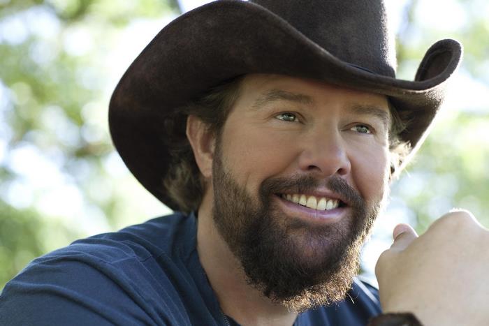 Toby Keith smiling outdoors in a cowboy hat