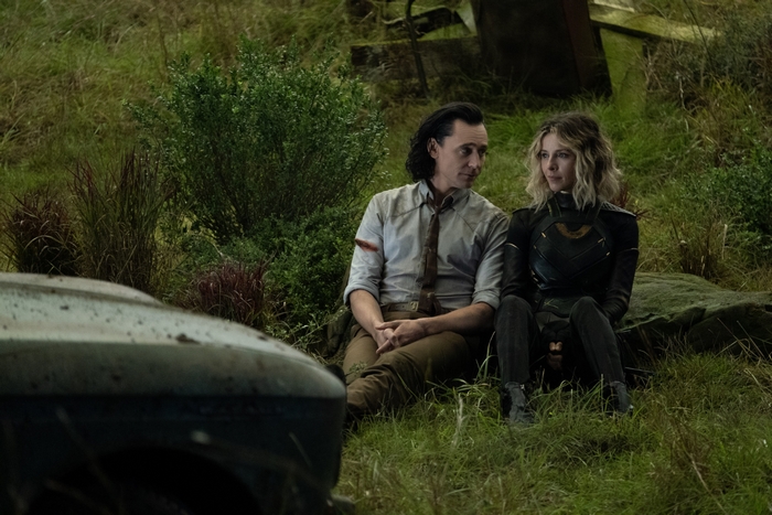 Loki and Sylvie sitting in a grassy field