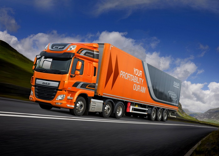 Orange DAF CF 440 truck on a scenic mountain road