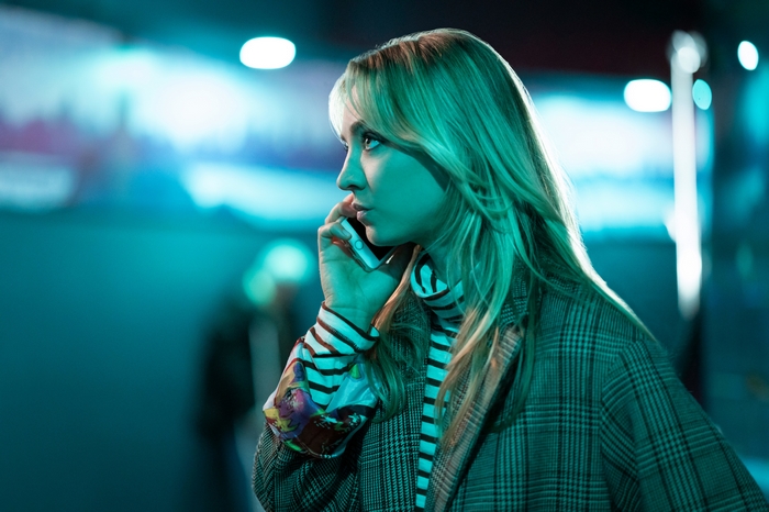 Kaley Cuoco on phone in teal light