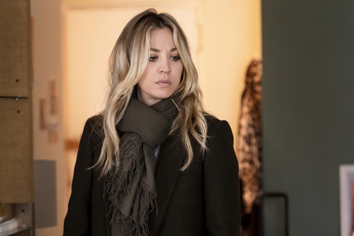 Kaley Cuoco looking pensive in a dark coat and scarf