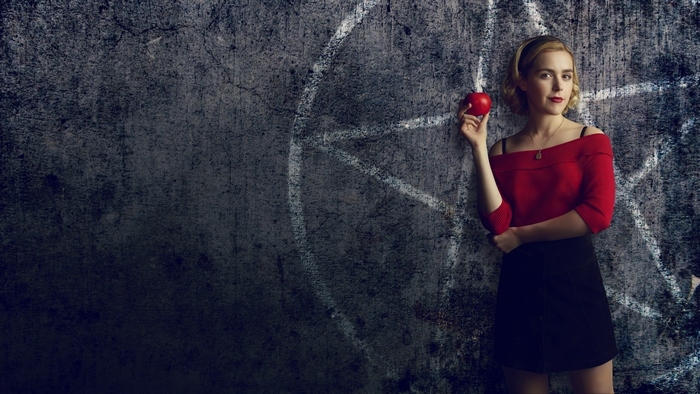 Sabrina Spellman with red apple and pentagram wall