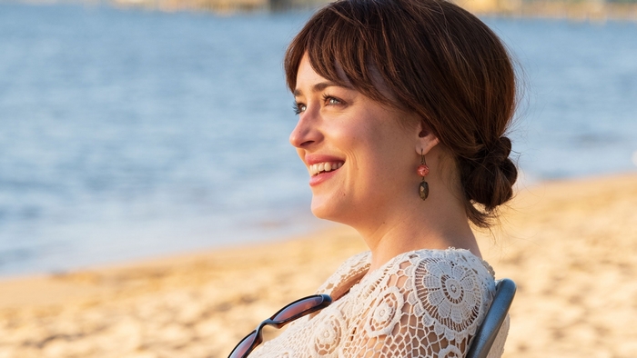 Dakota Johnson smiling on the beach in Our Friend