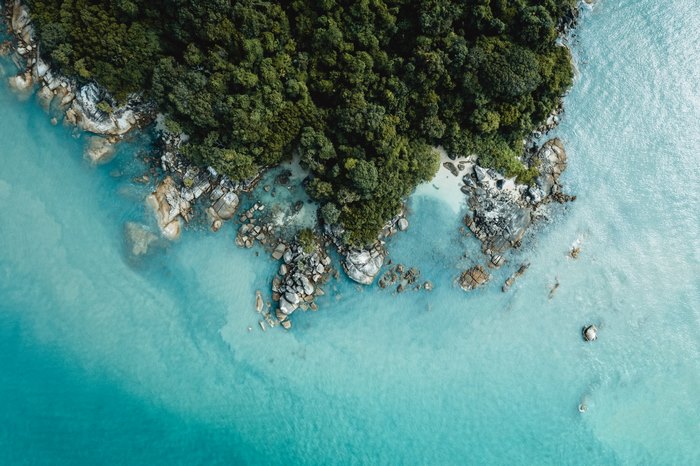 Aerial view of a lush island with clear turquoise ocean