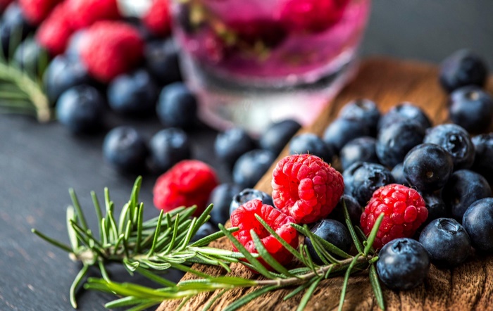 Blueberries, raspberries, and rosemary still life