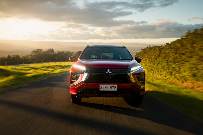 Red Mitsubishi Eclipse Cross PHEV SUV on a scenic road