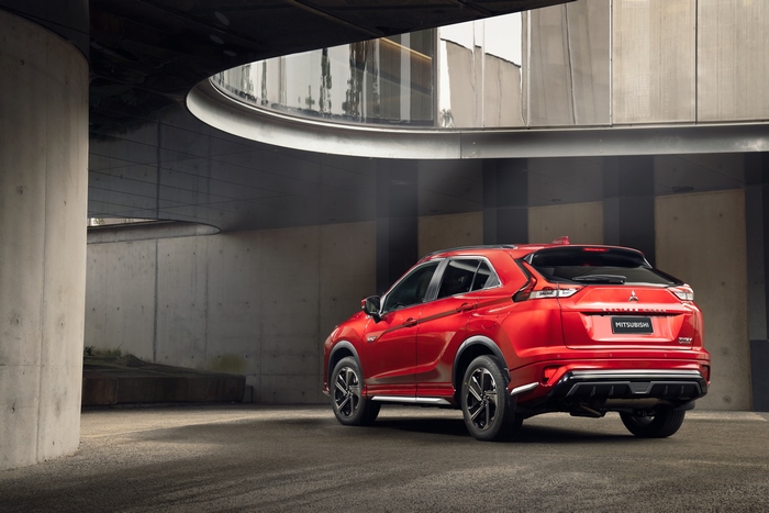 Red 2021 Mitsubishi Eclipse Cross PHEV SUV in modern concrete setting