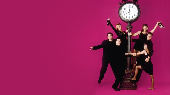 Friends cast in black around a clock street lamp