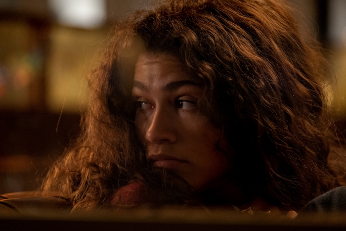 Pensive Zendaya with curly brown hair