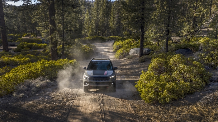 2022 Jeep Compass Trailhawk SUV driving on a dusty forest road